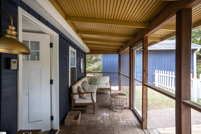 sunroom / solarium featuring beamed ceiling