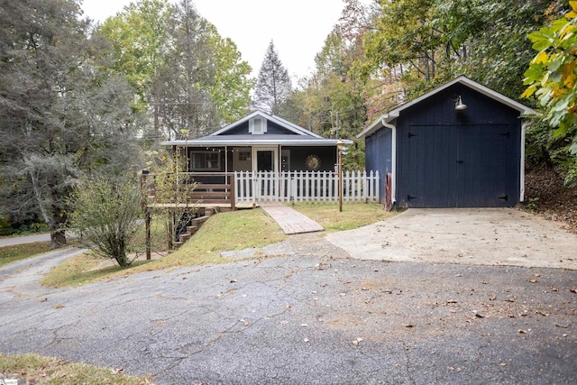 bungalow featuring an outbuilding, a porch, and a garage