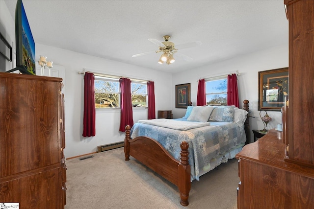 bedroom with light carpet, a textured ceiling, ceiling fan, and a baseboard heating unit