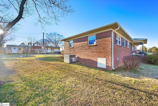 view of property exterior with central AC and a lawn