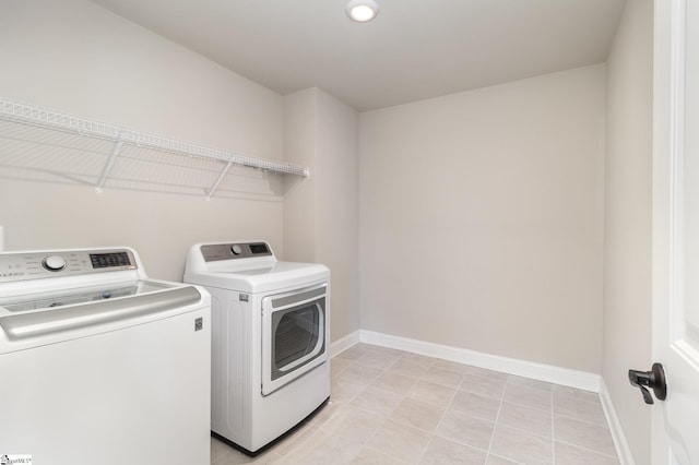 washroom featuring light tile patterned flooring and washing machine and clothes dryer