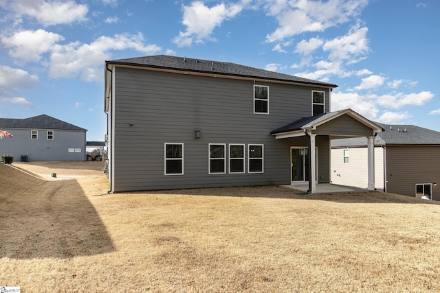 rear view of property with a yard and a patio area