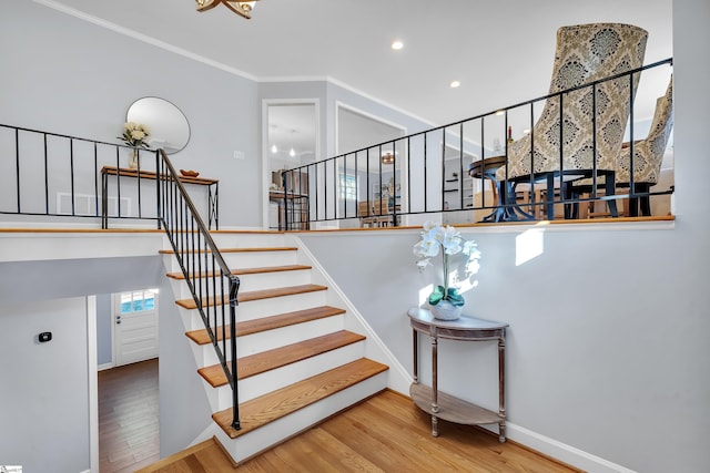 stairs featuring hardwood / wood-style flooring and ornamental molding