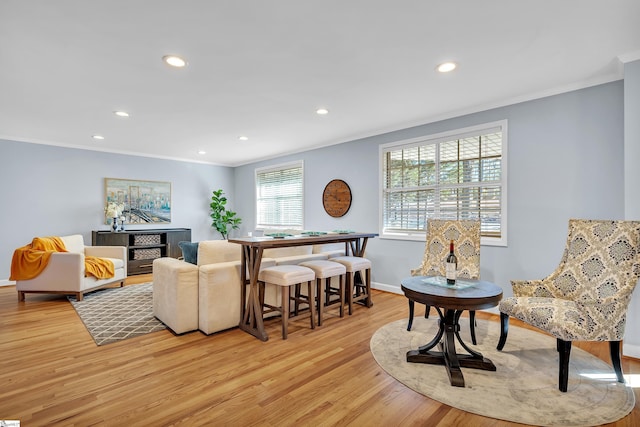 living room featuring light hardwood / wood-style floors and crown molding