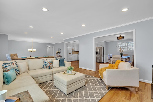 living room with wood-type flooring, crown molding, and a notable chandelier