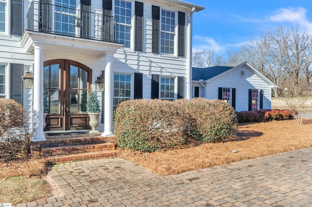 property entrance with a balcony and french doors