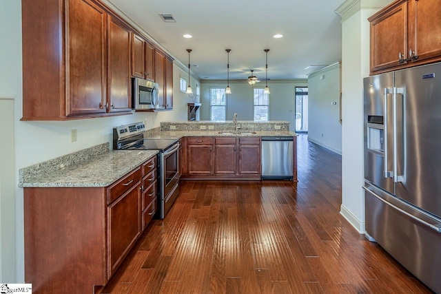 kitchen with sink, dark hardwood / wood-style floors, kitchen peninsula, pendant lighting, and appliances with stainless steel finishes