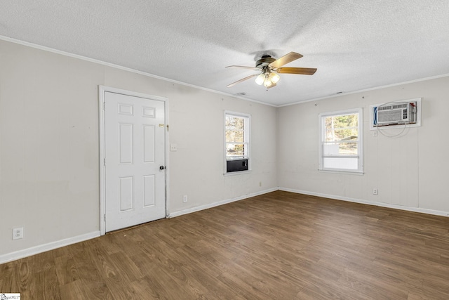 empty room featuring dark hardwood / wood-style floors, ceiling fan, crown molding, and a wall mounted AC