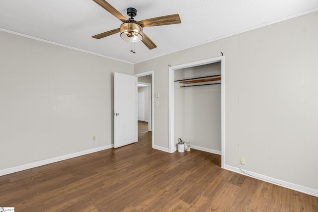 unfurnished bedroom with ceiling fan, ornamental molding, a textured ceiling, dark hardwood / wood-style flooring, and a closet