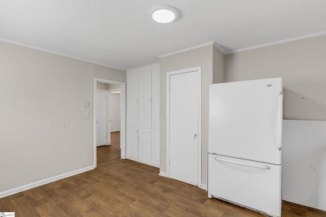 kitchen featuring dark hardwood / wood-style floors, white refrigerator, ornamental molding, and a textured ceiling