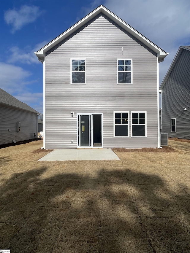 rear view of house featuring a yard, central AC, and a patio area