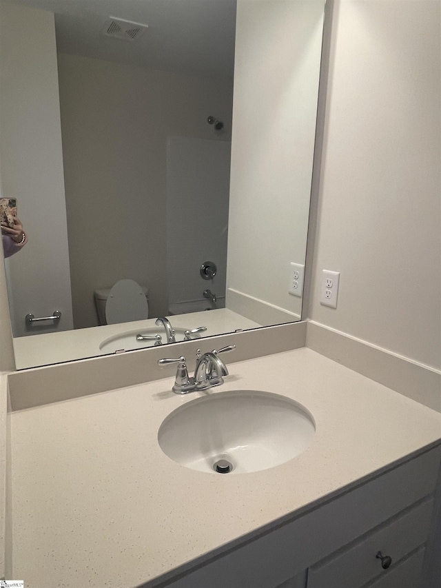 full bathroom with vanity, shower / tub combination, and toilet