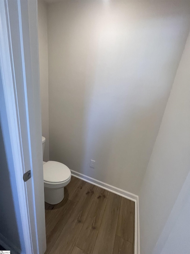 bathroom featuring wood-type flooring and toilet