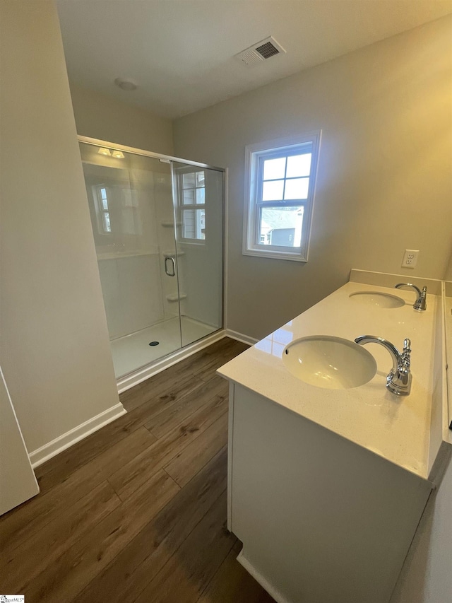 bathroom with vanity, an enclosed shower, and hardwood / wood-style floors