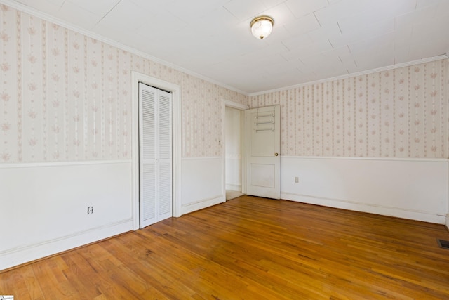 unfurnished bedroom with ornamental molding and hardwood / wood-style flooring