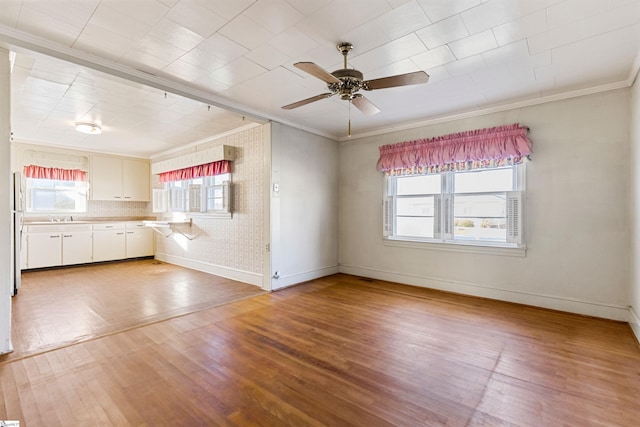 interior space featuring hardwood / wood-style flooring, plenty of natural light, crown molding, and ceiling fan