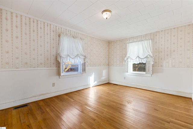 empty room with wood-type flooring and ornamental molding