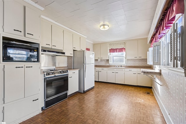 kitchen featuring white cabinetry, black microwave, dark parquet floors, white refrigerator, and stove