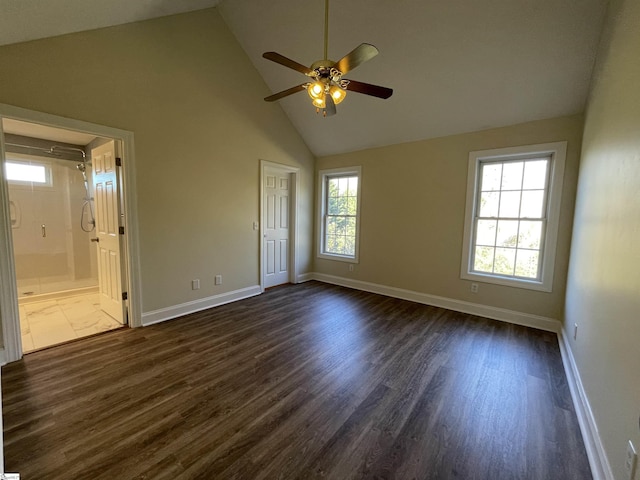 unfurnished bedroom featuring high vaulted ceiling, dark hardwood / wood-style floors, ensuite bath, and ceiling fan