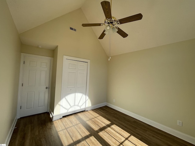 unfurnished bedroom with a closet, high vaulted ceiling, ceiling fan, and dark wood-type flooring