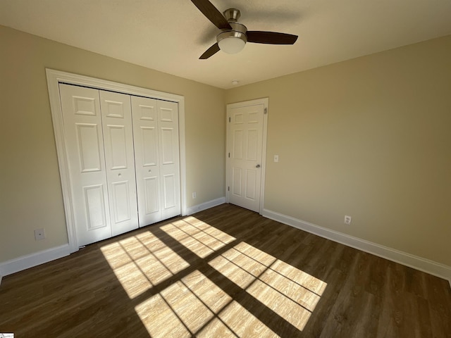 unfurnished bedroom with ceiling fan, dark hardwood / wood-style flooring, and a closet