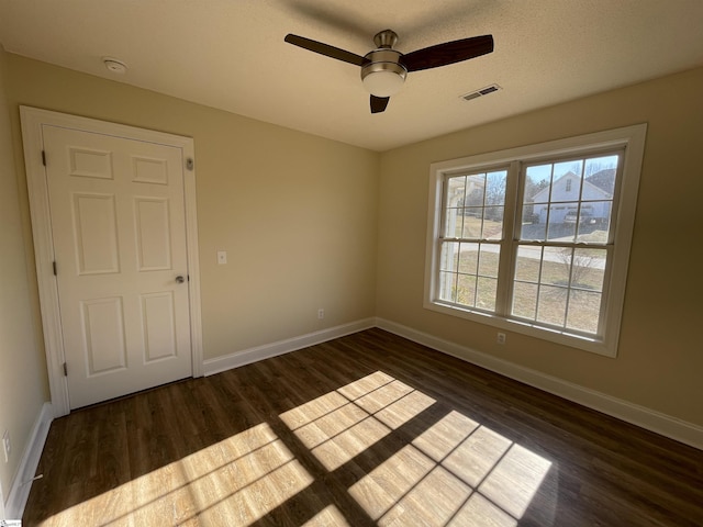 empty room with ceiling fan and dark wood-type flooring