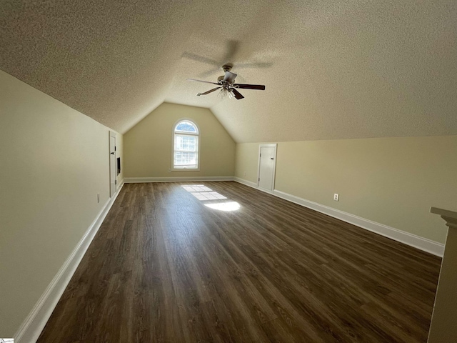 additional living space with a textured ceiling, dark hardwood / wood-style flooring, ceiling fan, and lofted ceiling