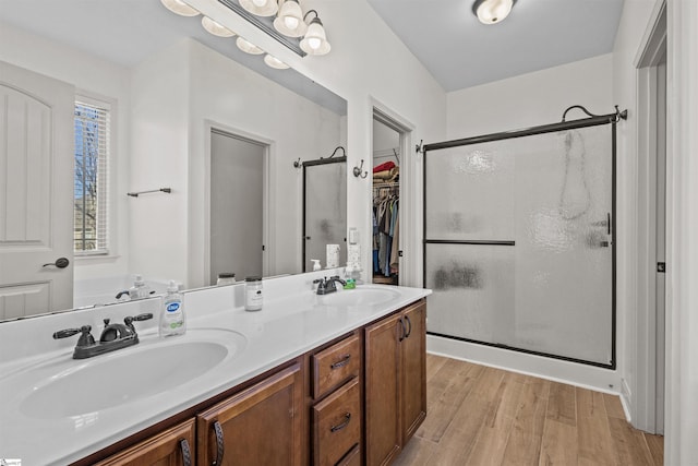 bathroom with hardwood / wood-style floors, vanity, and a shower with shower door