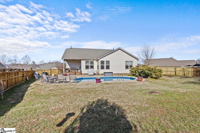 back of house featuring a lawn and a fenced in pool