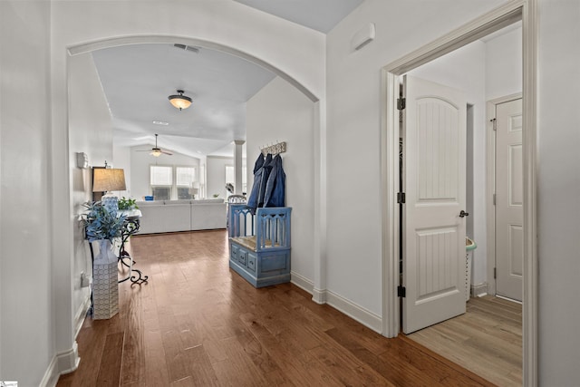 corridor with hardwood / wood-style floors and vaulted ceiling