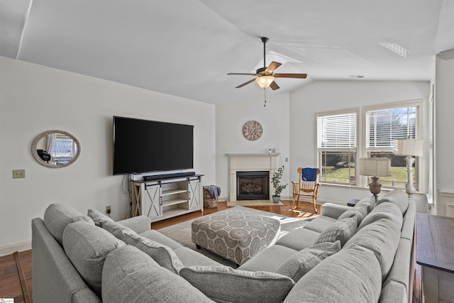 living room with ceiling fan, vaulted ceiling, and hardwood / wood-style flooring