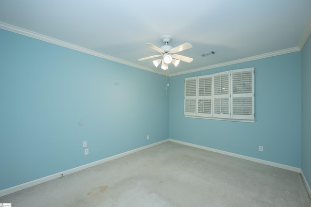 carpeted spare room with ceiling fan and ornamental molding