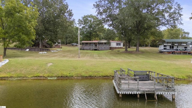 view of dock with a yard and a water view