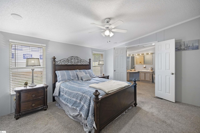 carpeted bedroom featuring ensuite bathroom, ornamental molding, a textured ceiling, ceiling fan, and lofted ceiling