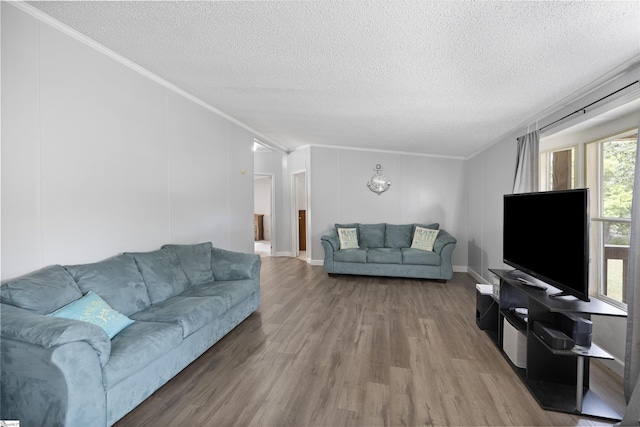 living room with a textured ceiling, hardwood / wood-style flooring, and ornamental molding