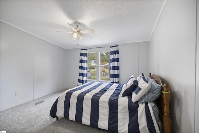 bedroom featuring carpet flooring, ceiling fan, and a textured ceiling