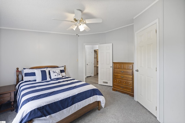 carpeted bedroom featuring ceiling fan, a textured ceiling, and ornamental molding