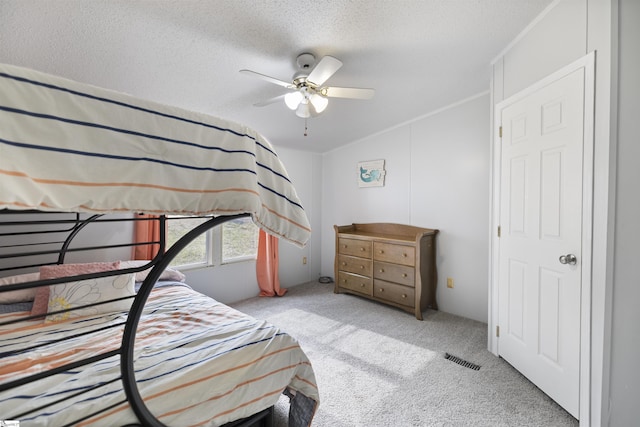 bedroom featuring ceiling fan, light carpet, and a textured ceiling