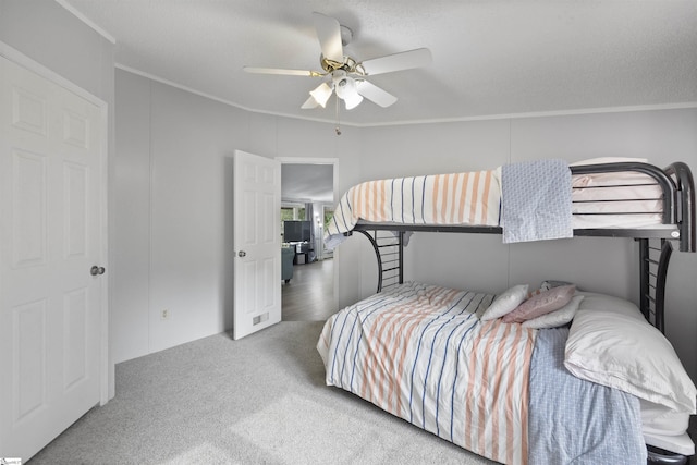 bedroom with carpet, ceiling fan, and ornamental molding