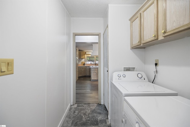 washroom featuring washing machine and dryer, sink, cabinets, and a textured ceiling