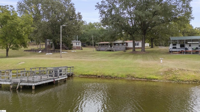 dock area with a lawn and a water view