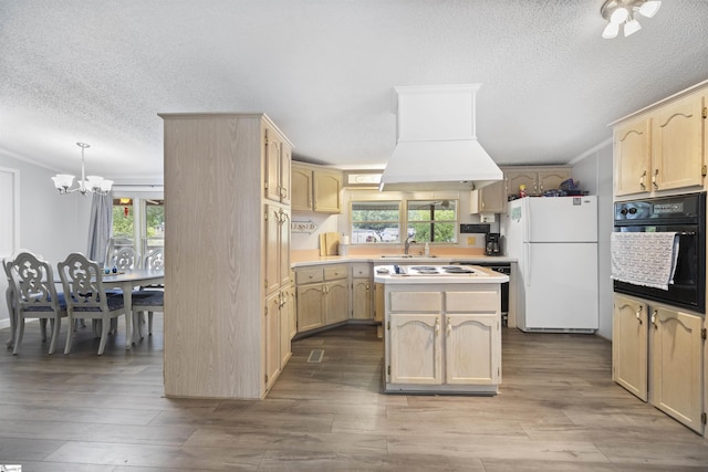 kitchen with a notable chandelier, white appliances, light brown cabinetry, and a wealth of natural light