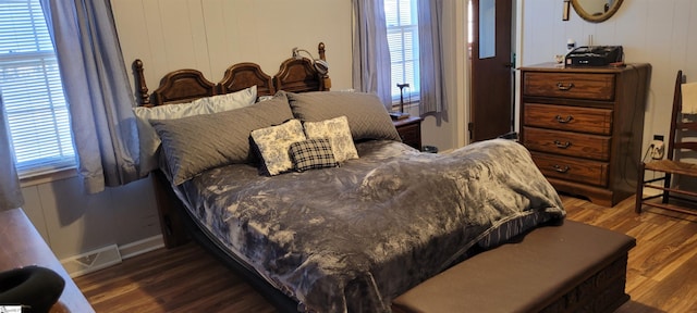 bedroom featuring dark hardwood / wood-style floors and multiple windows