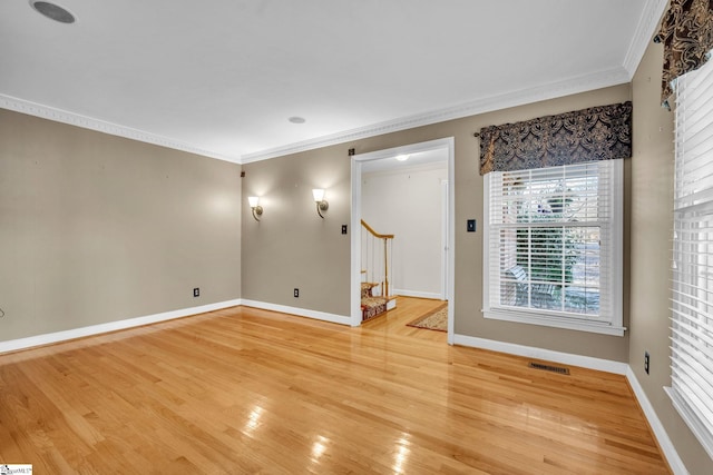 empty room with wood-type flooring and ornamental molding