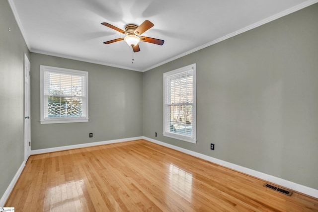 unfurnished room featuring a wealth of natural light, light hardwood / wood-style floors, and ornamental molding