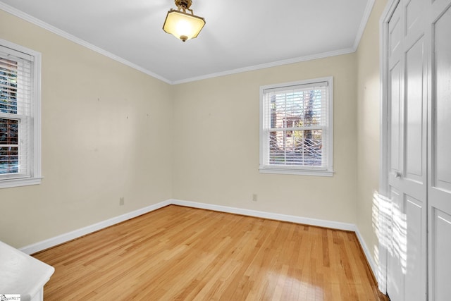 spare room featuring light wood-type flooring and ornamental molding