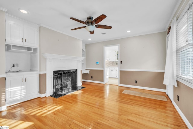 unfurnished living room featuring light hardwood / wood-style floors, ceiling fan, and ornamental molding