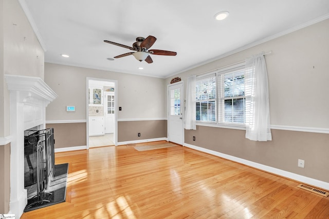 unfurnished living room with hardwood / wood-style flooring, ceiling fan, and crown molding