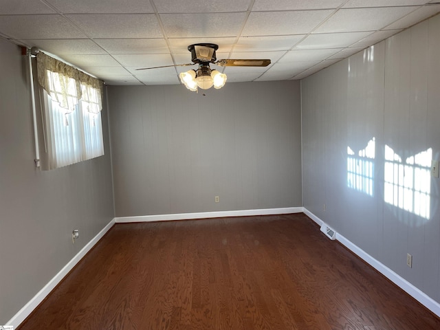 unfurnished room featuring a paneled ceiling, dark hardwood / wood-style floors, and ceiling fan