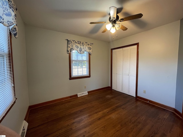 unfurnished bedroom featuring a closet, ceiling fan, and dark wood-type flooring